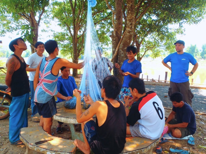 Villagers preparing sampling gillnet with weights and floats 