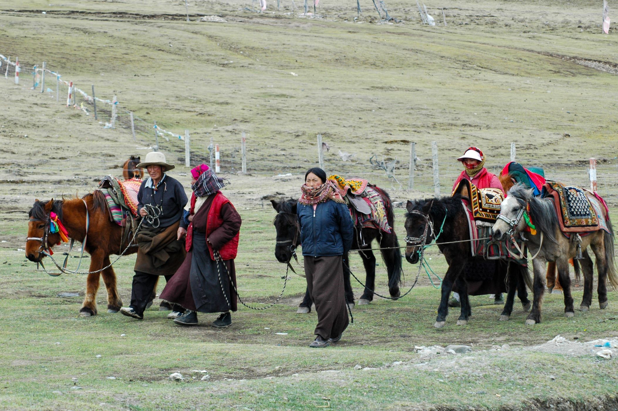 A group of villagers walk their horses
