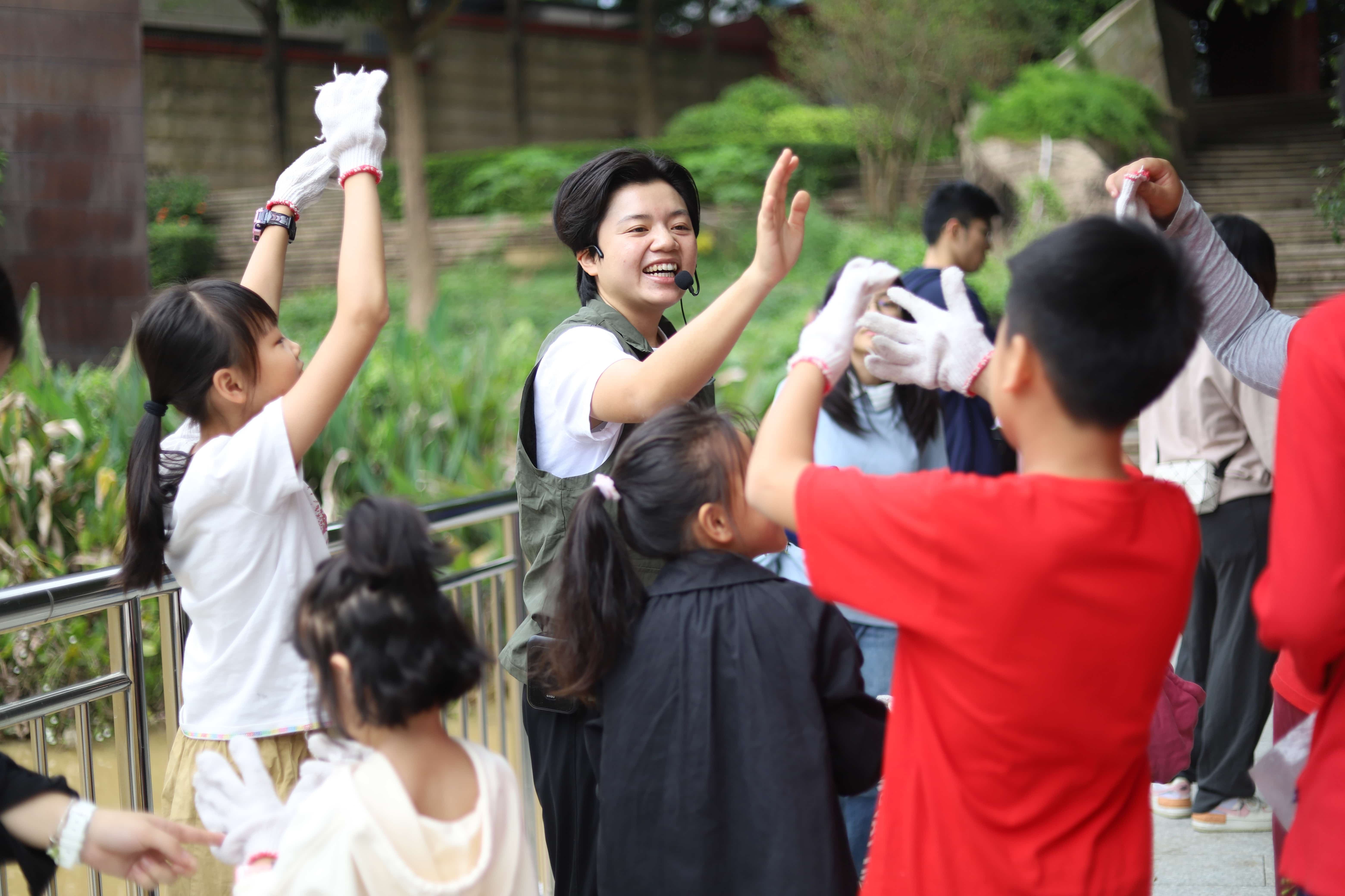 Young woman high-fiving group of children
