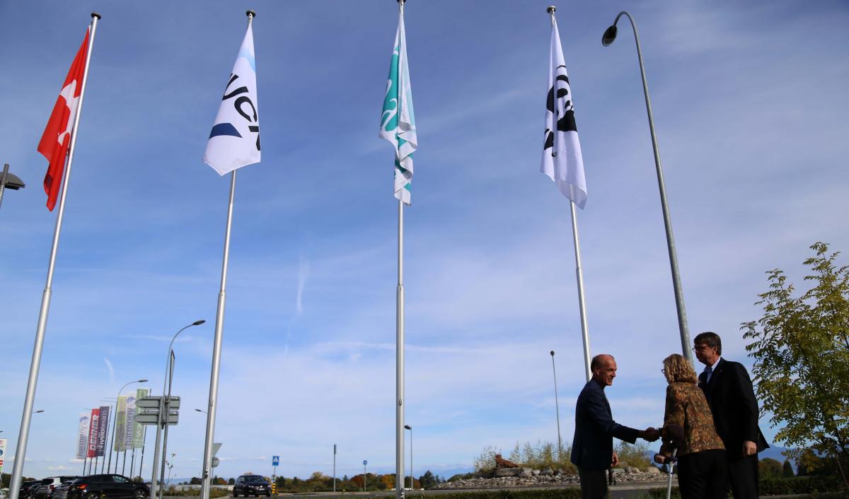 Marco Lambertini, Inger Andersen, André Hoffmann and flags outside the IUCN Conservation Centre 10 October 2017