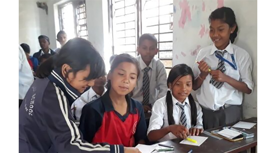 School girls in Nepal comparing postcard drawings
