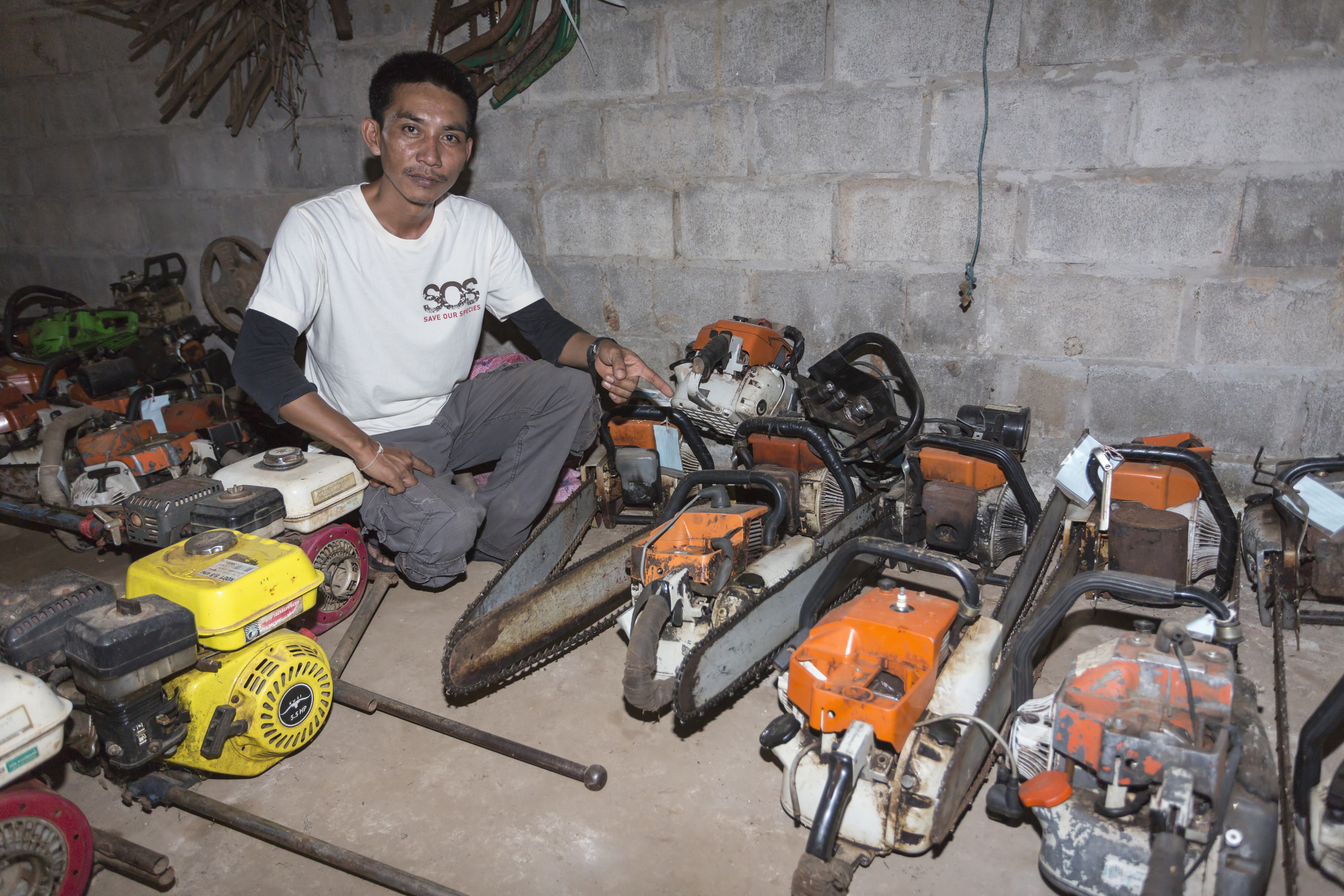 Sayan Raksachart of Freeland, with confiscated outboard motors and chainsaws, used by poachers