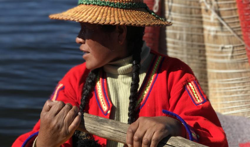 A Quichua woman rowing her reed boat, photo taken during a field mission on the implementation of the climate change Gender Action Plan (ccGAP) for Peru