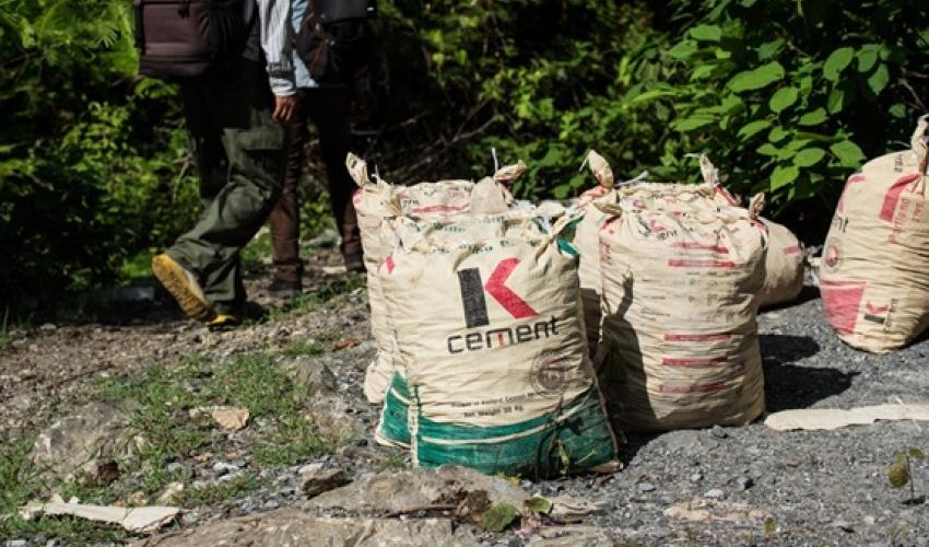Members of the survey team pass bags of cement, produced from the limestones in the hills © Steven Bernacki, IUCN