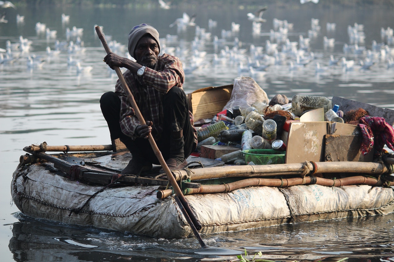Man collecting waste in a boat