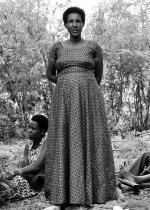 woman standing in dress with people at her feet