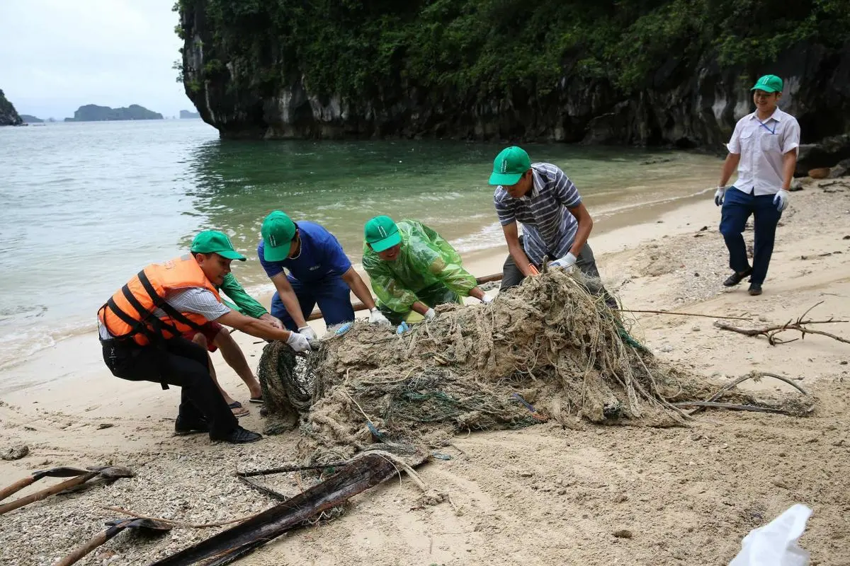 Mr. Huynh - Deputy Director of Ha Long Bay Management Board joined with volunteers to collect huge fishing nets left on the beach in Ha Long 
