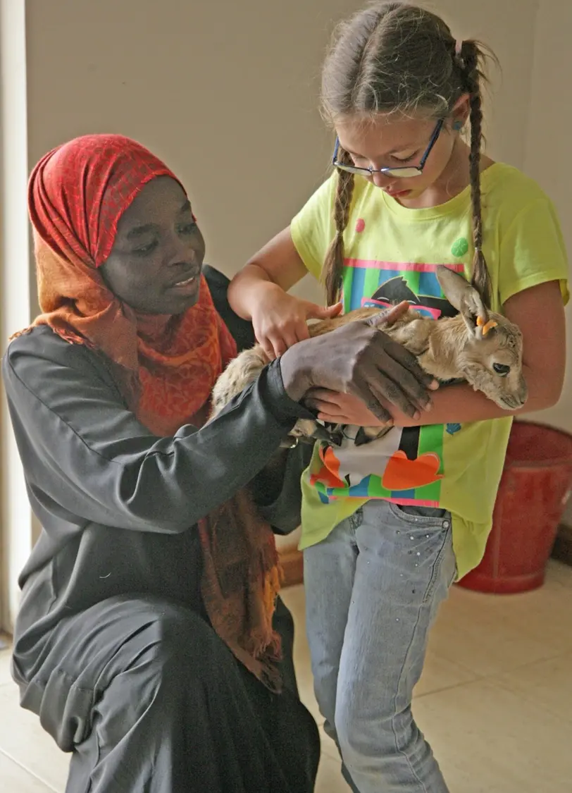 Aishah explaining gazelle fawn care to a young student at the King Khalid Wildlife Research Center, Riyadh